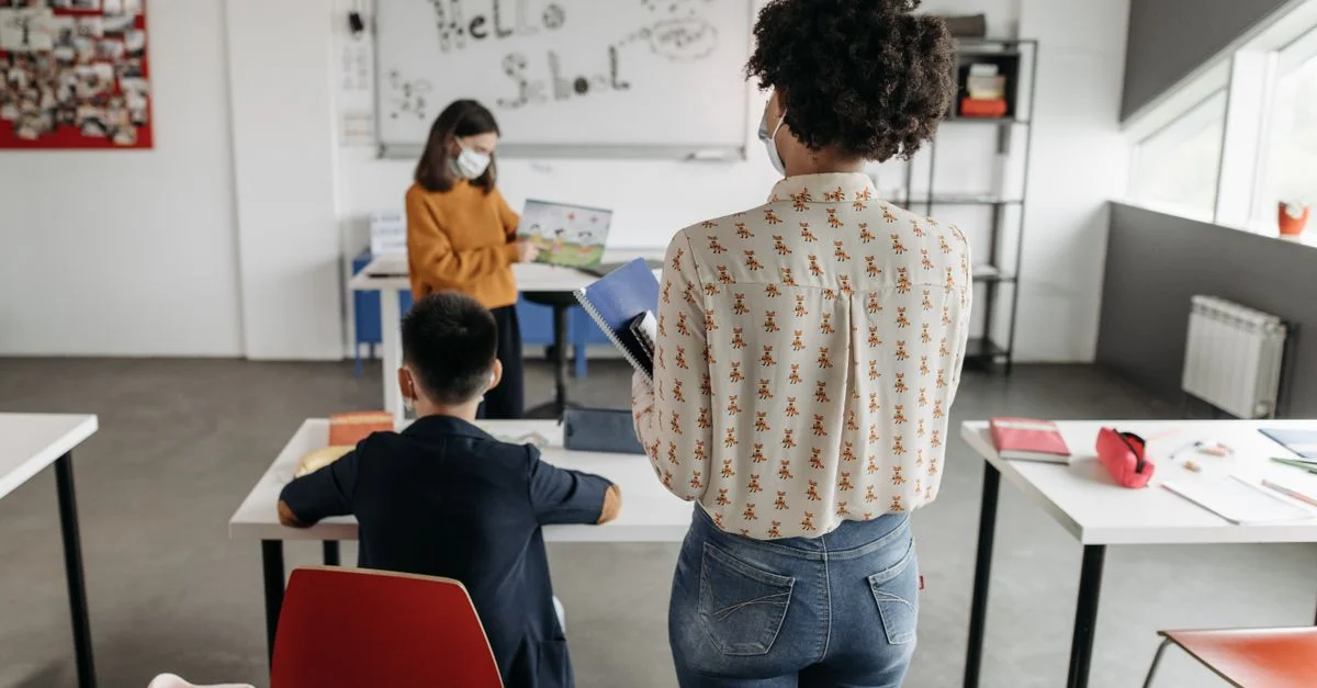 Enseignant et élèves dans une classe bien éclairée pendant une leçon.