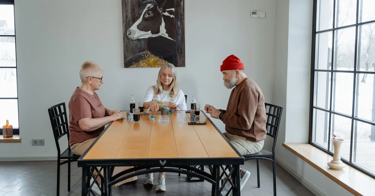 Un groupe de seniors jouant aux cartes à l'intérieur, profitant de leur temps libre ensemble.